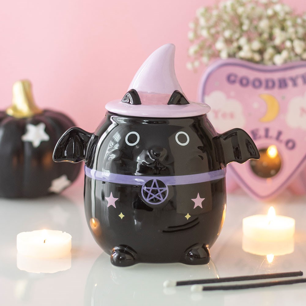 Kawaii Cauldron Bat Oil Burner – Lifestyle mit Teelichtern und Ouija-Brett auf rosa Hintergrund