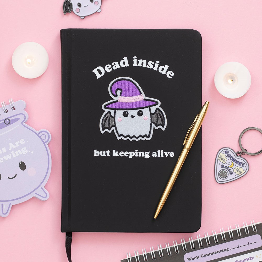 Dead Inside but Keeping Alive Journal – Lifestyle mit Kerzen und Stift auf rosa Hintergrund