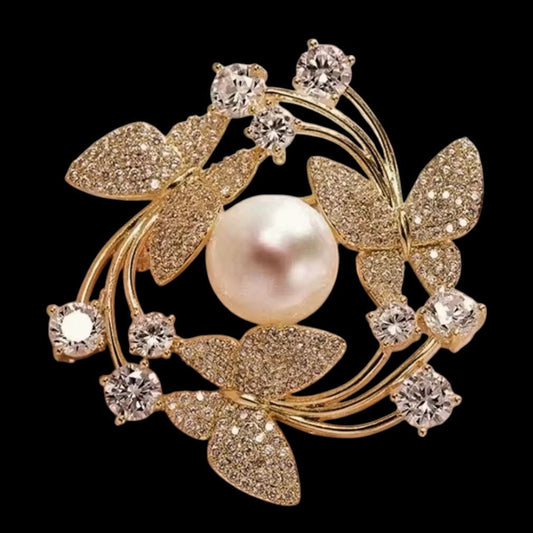 Schmetterlings-Brosche Gold mit Perle und Zirkonia auf schwarzem Hintergrund