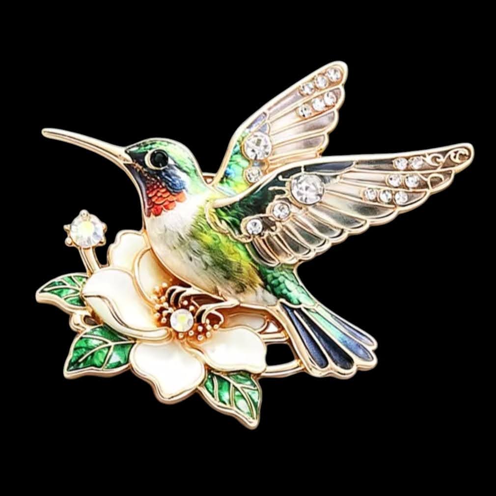 Kolibri-Brosche grün mit weißer Blüte und Strass auf schwarzem Hintergrund