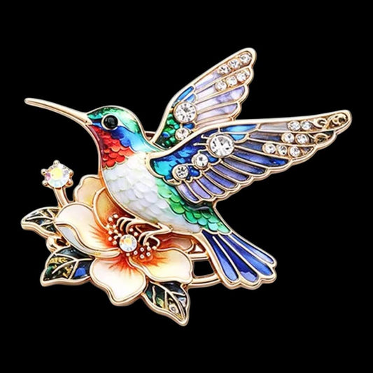 Kolibri-Brosche blau mit orangefarbener Blüte und Strass auf schwarzem Hintergrund