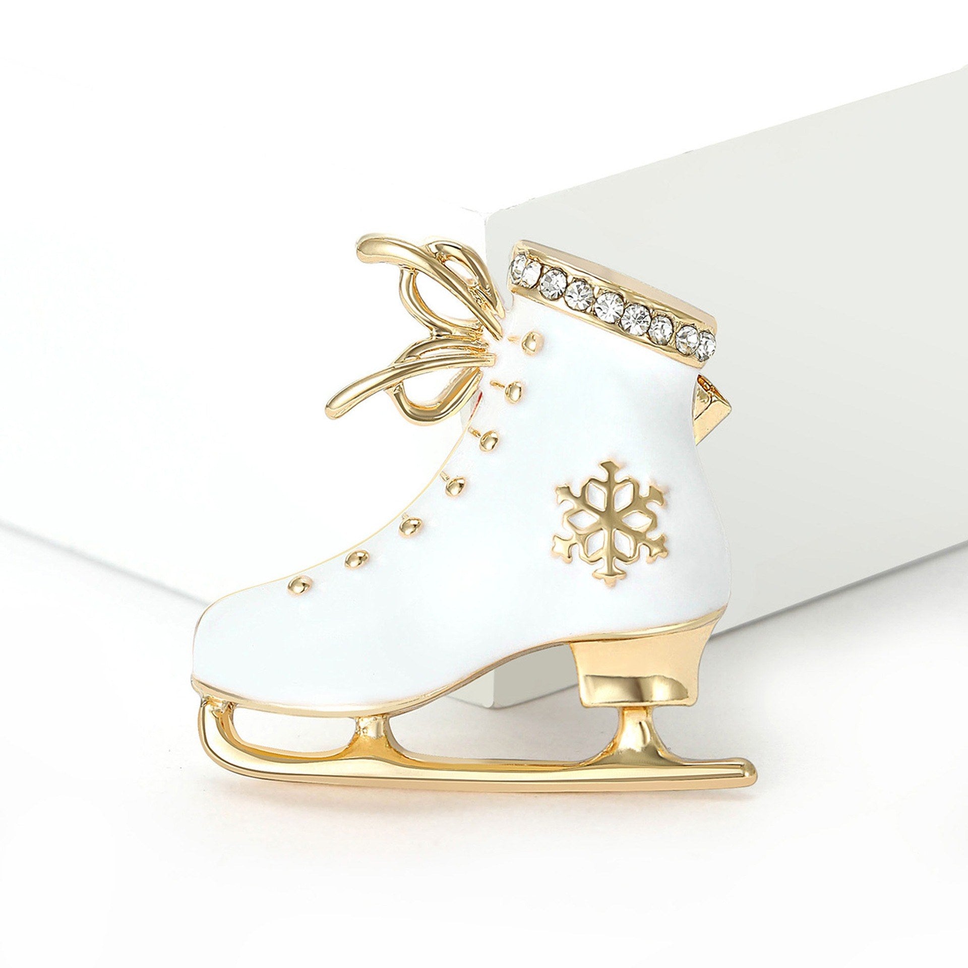 Vintage Schlittschuhbrosche Weiß-Gold – Draufsicht weißer Hintergrund