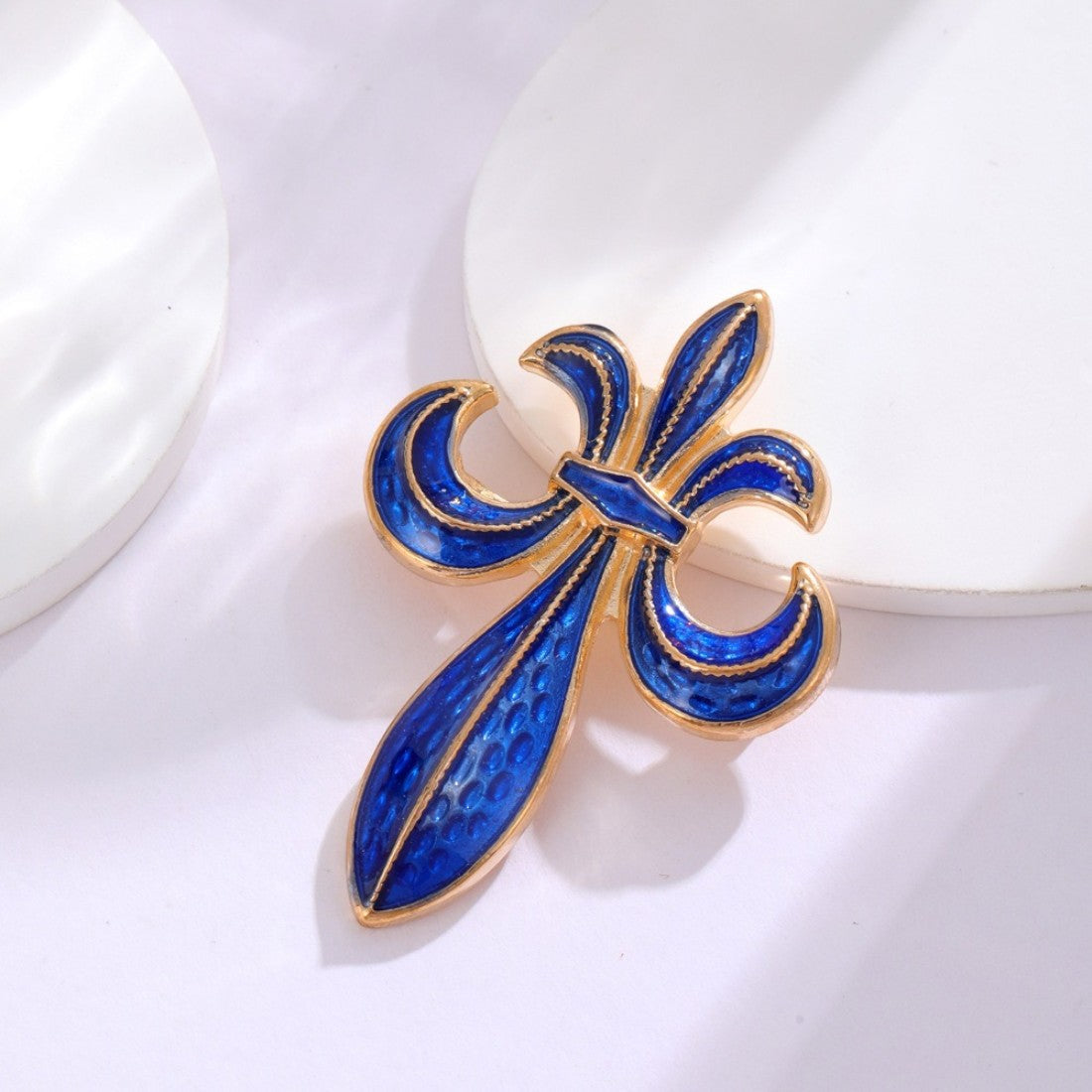 Fleur-de-Lis Brosche blau/gold auf weißem Hintergrund