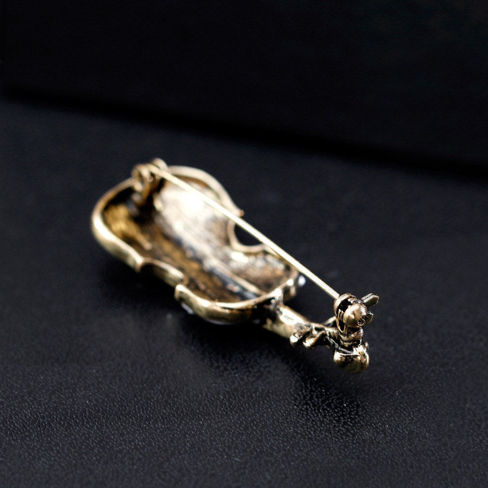Geigen-Brosche – Seitenansicht liegend auf schwarzem Untergrund